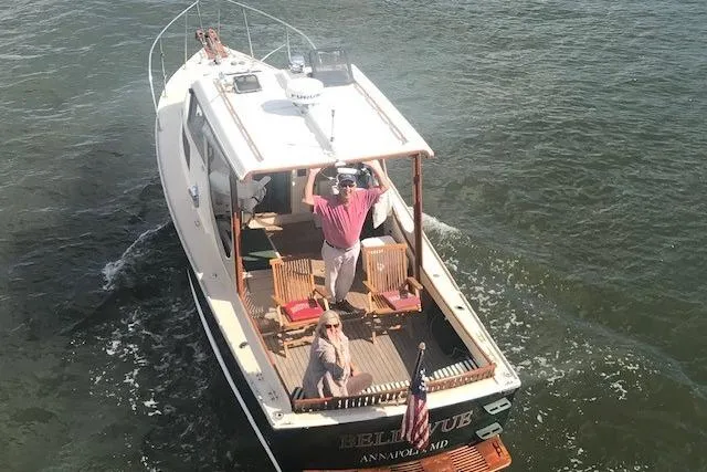 Slide: The Image of 1960 Dyer Hard Top boat cruising with passengers on deck, American flag displayed. - 7