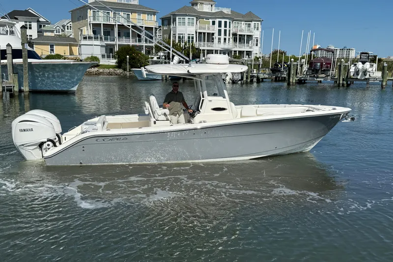 The Image of 2023 Cobia 280 Center Console boat in marina, featuring Yamaha engines. - 0