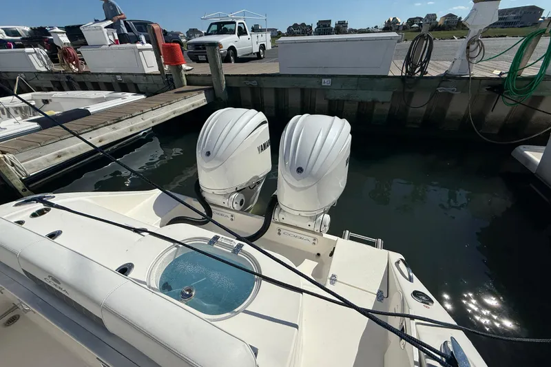 Slide: The Image of 2023 Cobia 280 Center Console with twin Yamaha outboard engines docked at marina. - 10