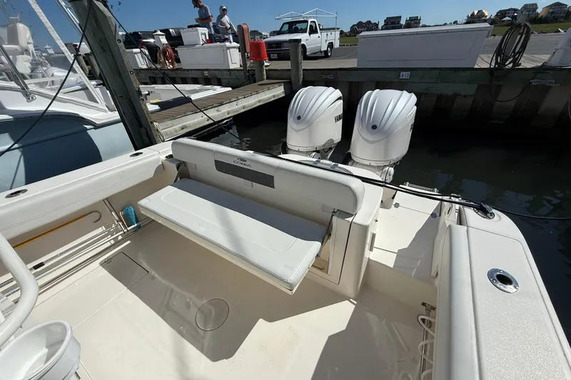 Slide: The Image of 2023 Cobia 280 Center Console boat with dual Yamaha engines docked at marina. - 11