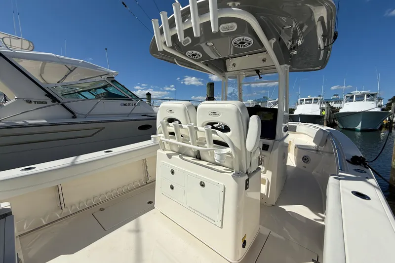 Slide: The Image of 2023 Cobia 280 Center Console boat interior with helm and seating, docked at marina. - 13