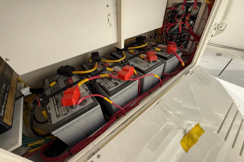 Slide: The Image of 2023 Cobia 280 Center Console boat battery compartment with multiple connected batteries. - 25