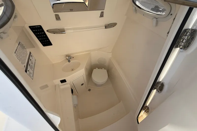 Slide: The Image of 2023 Cobia 280 Center Console boat interior with compact bathroom amenities. - 34
