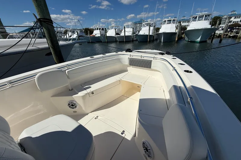 Slide: The Image of 2023 Cobia 280 Center Console boat docked, featuring spacious seating and clear blue skies. - 35