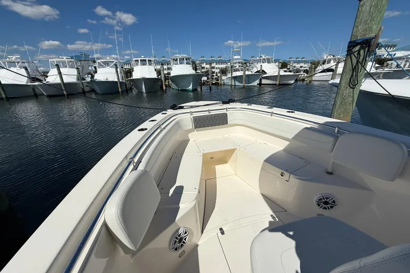 Slide: The Image of 2023 Cobia 280 Center Console boat docked at marina under clear blue sky. - 36