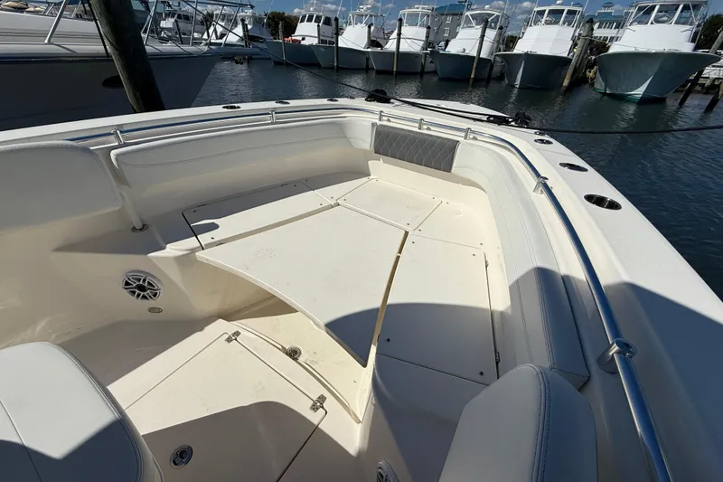 Slide: The Image of 2023 Cobia 280 Center Console boat interior with seating and storage, docked at marina. - 37