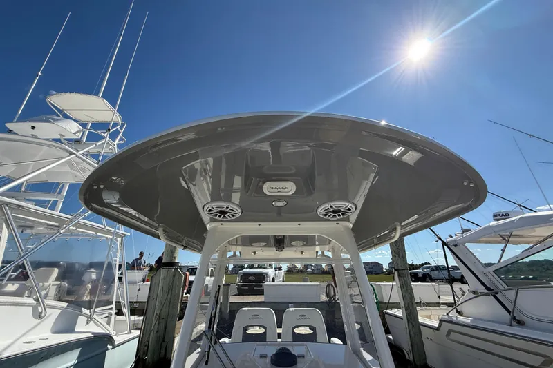 Slide: The Image of 2023 Cobia 280 Center Console boat under bright sun at marina. - 42