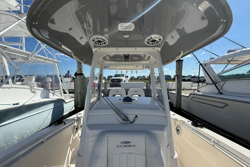 Slide: The Image of 2023 Cobia 280 Center Console boat at marina, showcasing helm and seating area. - 43