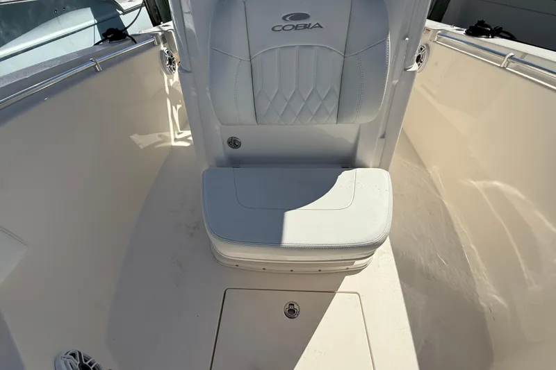 Slide: The Image of 2023 Cobia 280 Center Console boat interior with cushioned seating and storage compartment. - 45