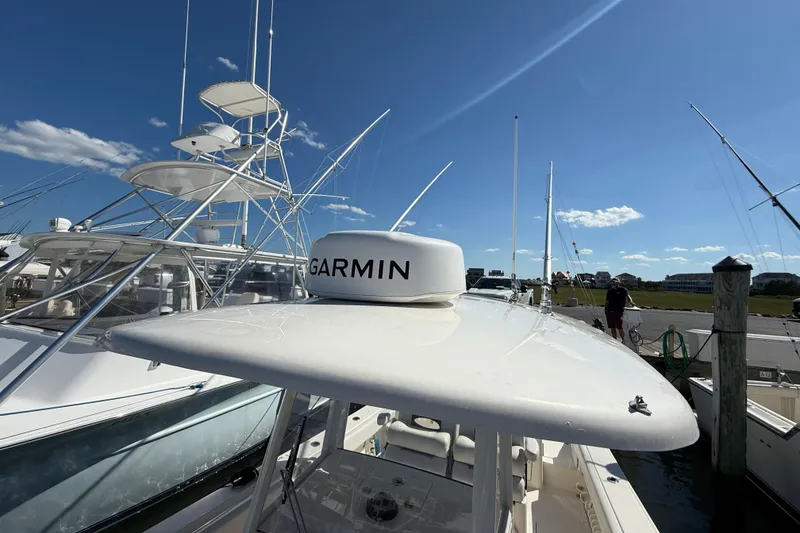 Slide: The Image of 2023 Cobia 280 Center Console boat with Garmin equipment, docked under clear blue sky. - 46