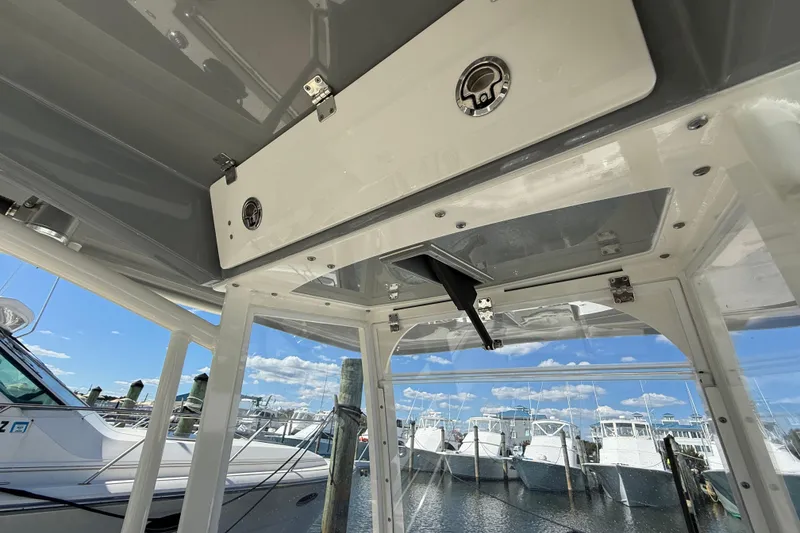 Slide: The Image of 2023 Cobia 280 Center Console boat interior with storage compartment, docked at marina. - 51