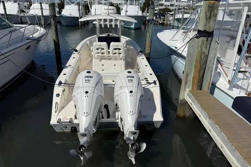 Slide: The Image of 2023 Cobia 280 Center Console boat docked with twin 300 V6 engines. - 53