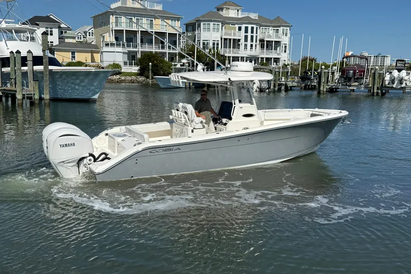 Slide: The Image of 2023 Cobia 280 Center Console boat in marina, featuring Yamaha engines. - 8