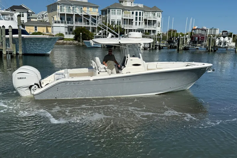Slide: The Image of 2023 Cobia 280 Center Console boat in marina, featuring Yamaha engine. - 9