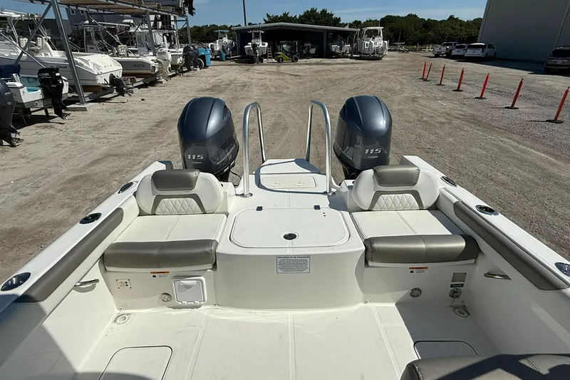 Slide: The Image of 2023 World Cat 230 DC boat with dual Yamaha 115 engines, docked in a marina. - 16