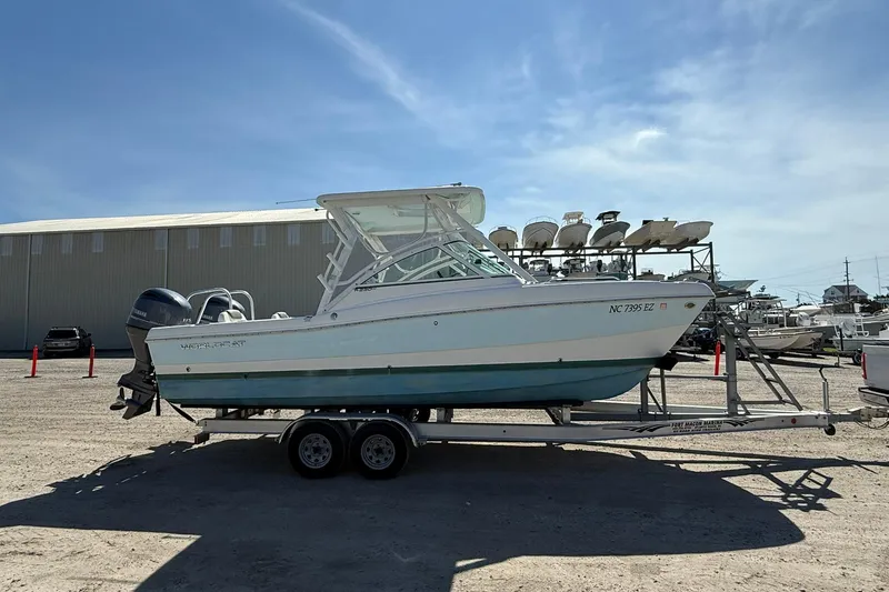 Slide: The Image of 2023 World Cat 230 DC boat on trailer in marina setting. - 6
