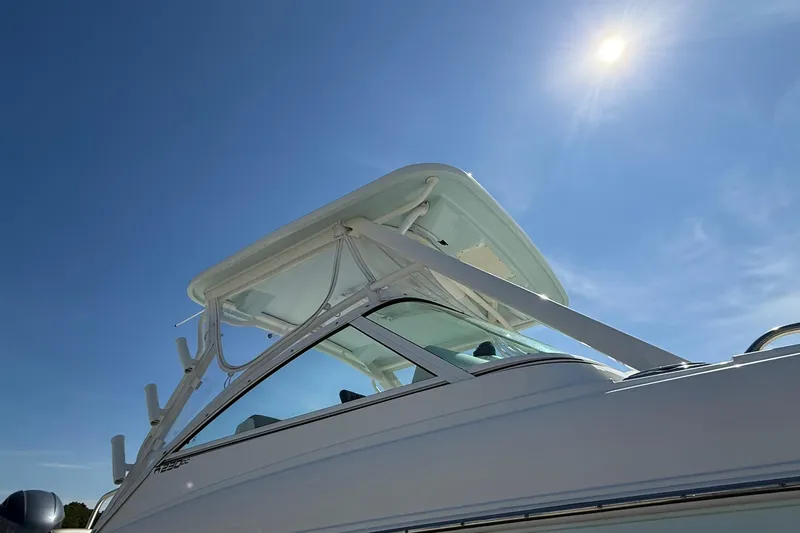 Slide: The Image of 2023 World Cat 230 DC boat under clear blue sky with sun shining. - 7