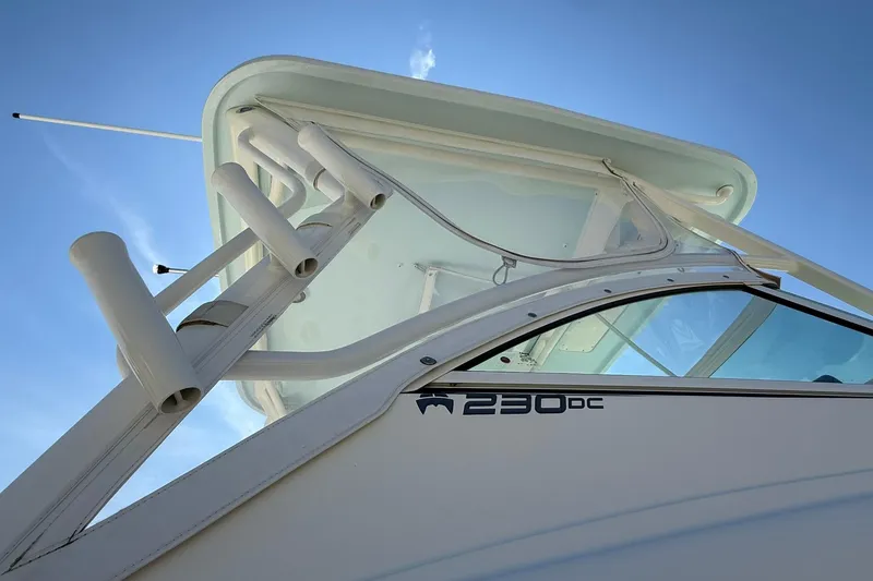Slide: The Image of 2023 World Cat 230 DC boat, close-up of upper structure against clear blue sky. - 8