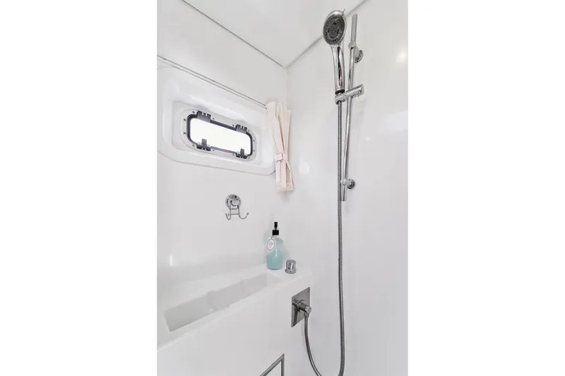 Slide: The Image of Shower area in 2012 Lagoon 560 yacht with chrome fixtures and porthole window. - 105