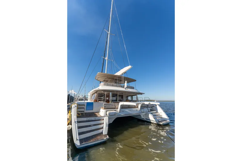 Slide: The Image of Lagoon 560 catamaran, 2012 model, docked on calm waters under clear blue sky. - 11