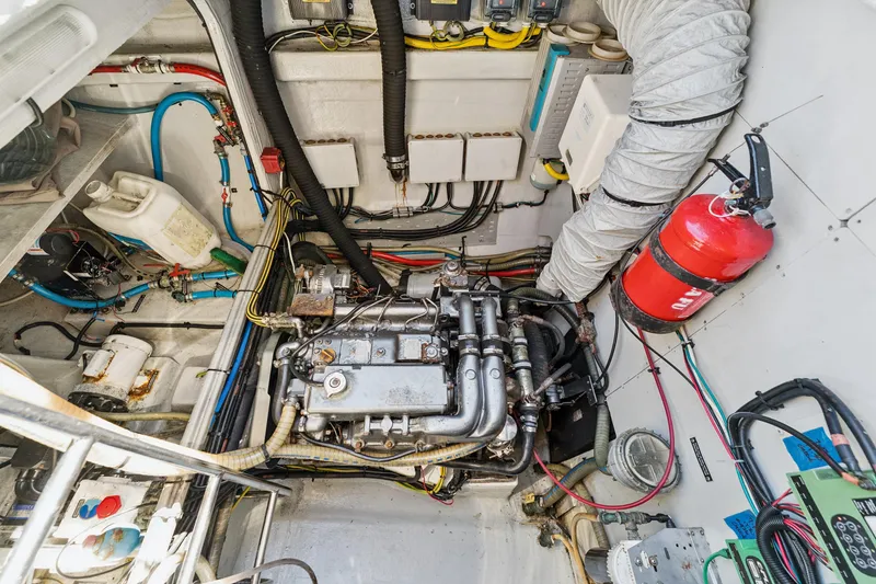 Slide: The Image of Engine room of a 2012 Lagoon 560 yacht, featuring mechanical components and a fire extinguisher. - 121