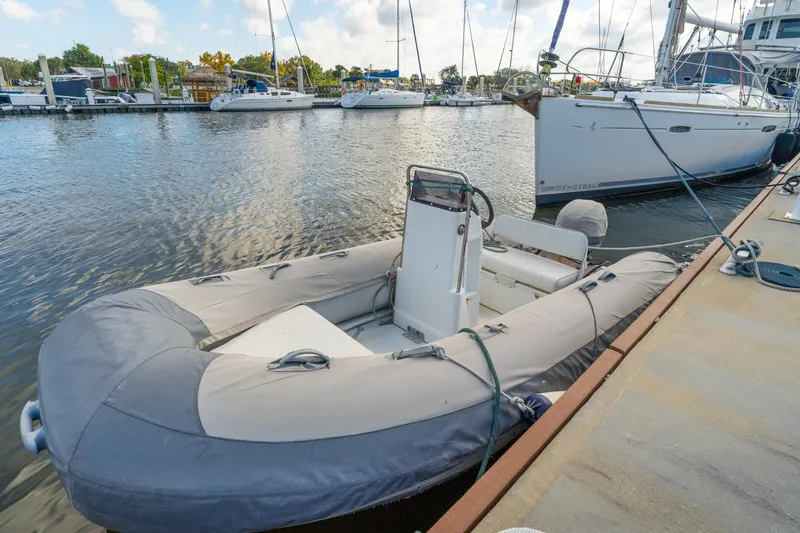 Slide: The Image of Inflatable dinghy moored beside a Lagoon 560 yacht, 2012 model, in a marina. - 128