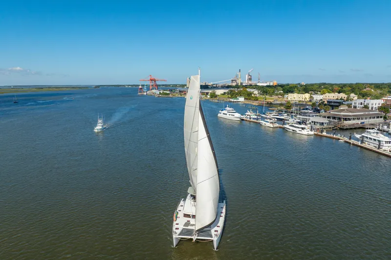 Slide: The Image of Aerial view of 2012 Lagoon 560 catamaran sailing near a marina on a sunny day. - 138