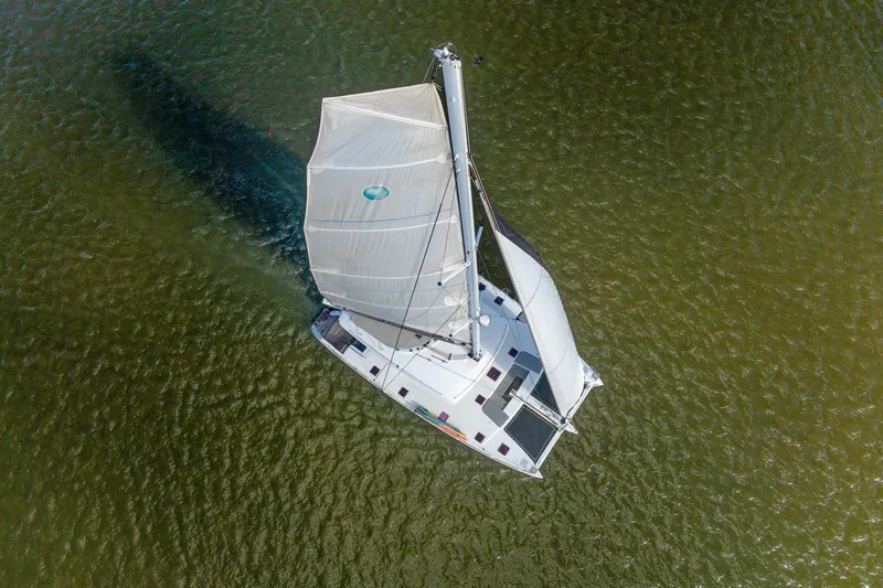 Slide: The Image of Aerial view of 2012 Lagoon 560 catamaran sailing on green water. - 139