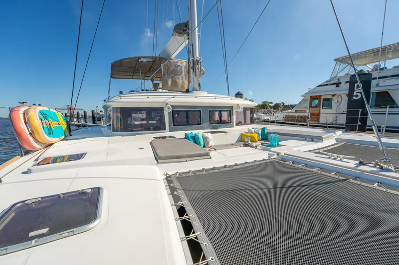 Slide: The Image of 2012 Lagoon 560 catamaran docked, featuring spacious deck and vibrant seating. - 19