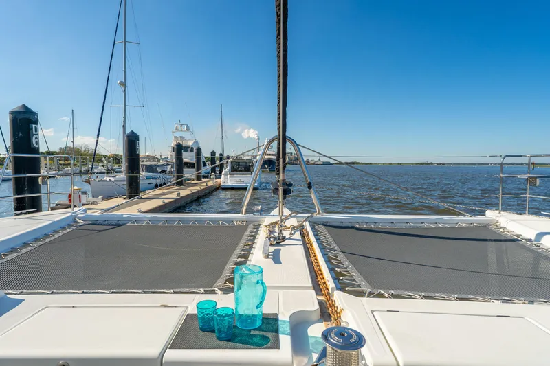 Slide: The Image of Lagoon 560 catamaran docked at marina, featuring deck with blue glasses, 2012 model. - 21