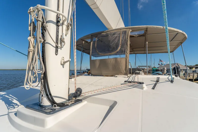Slide: The Image of Lagoon 560 catamaran deck view, 2012 model, with ropes and canopy under clear blue sky. - 22