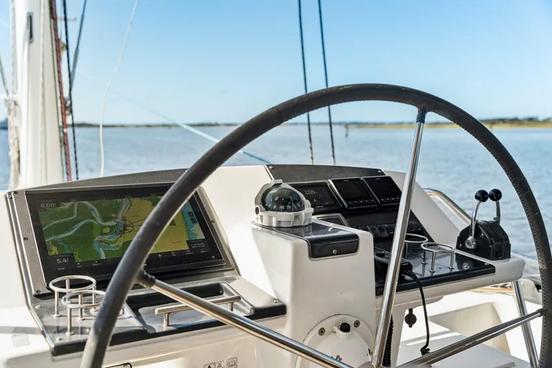Slide: The Image of Steering wheel and navigation system on 2012 Lagoon 560 yacht, overlooking calm waters. - 39