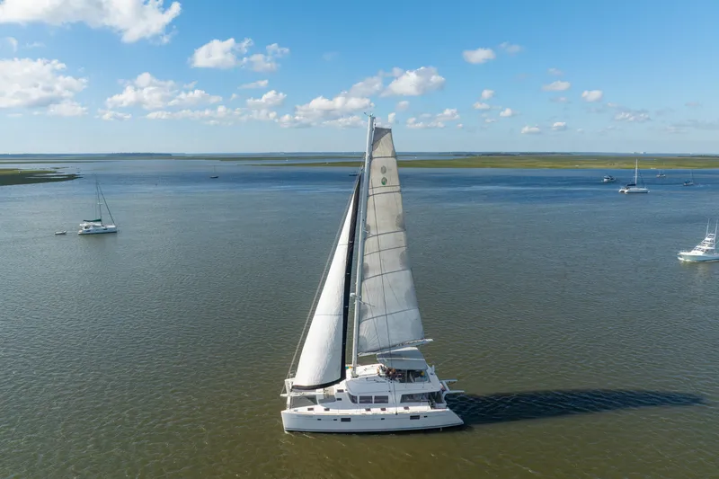 Slide: The Image of Sailing Lagoon 560 catamaran from 2012 on calm waters under a clear blue sky. - 4