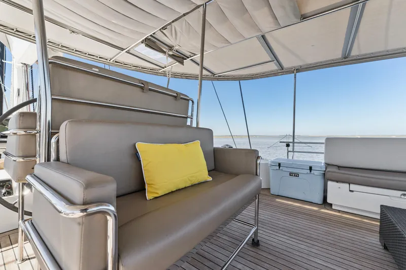 Slide: The Image of Luxurious Lagoon 560 yacht deck with seating, yellow cushion, and ocean view, 2012 model. - 45