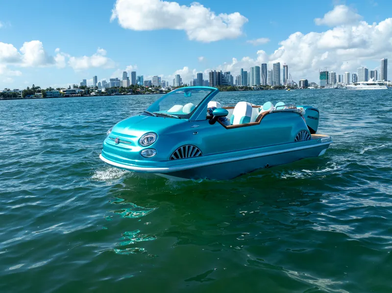 The Image of 2025 Car Off-shore Fiat 500 Classic boat on water with city skyline background. - 0