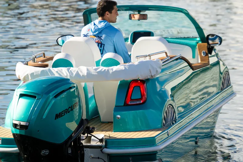 Slide: The Image of 2025 Car Off-shore Fiat 500 Classic boat on water, featuring teal design and Mercury engine. - 12