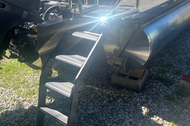 Slide: The Image of 2026 Avalon 25 LSZ Versatile Rear Lounger pontoon boat with ladder on gravel. - 8