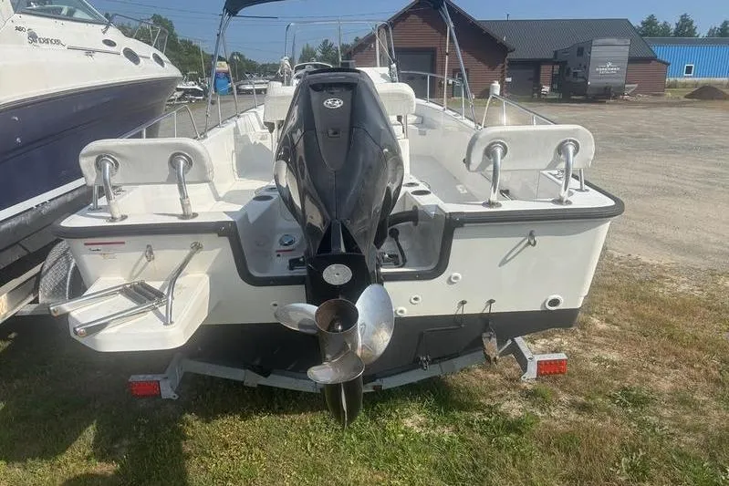 Slide: The Image of 2012 Boston Whaler 210 Montauk boat with outboard motor, parked on grass. - 6