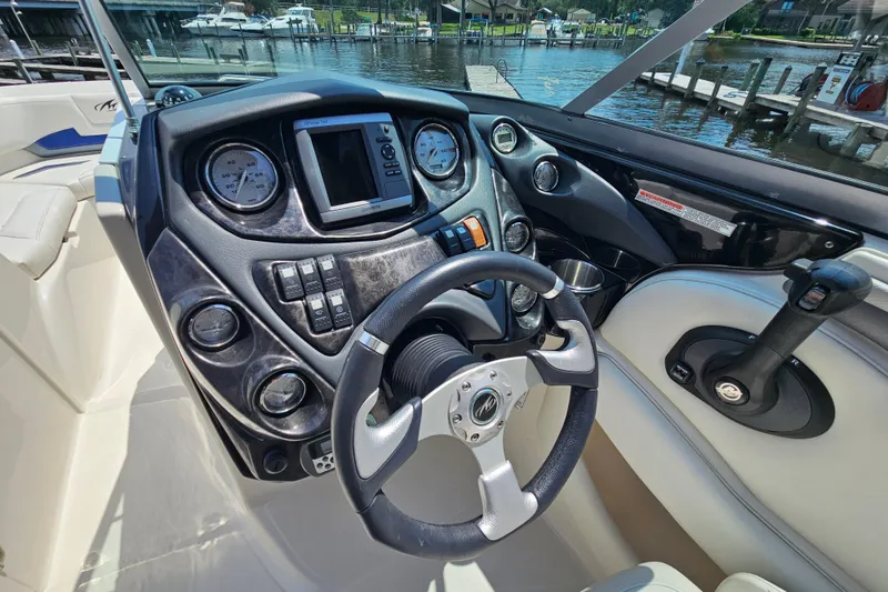 Slide: The Image of 2011 Monterey 244FS boat dashboard with steering wheel and control panel. - 10