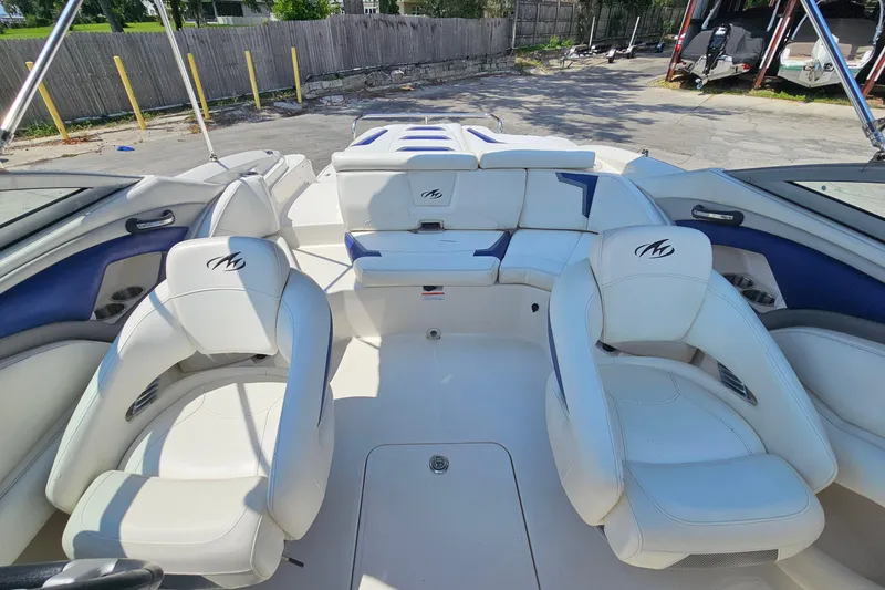 Slide: The Image of Interior of a 2011 Monterey 244FS boat with white and blue seating. - 13