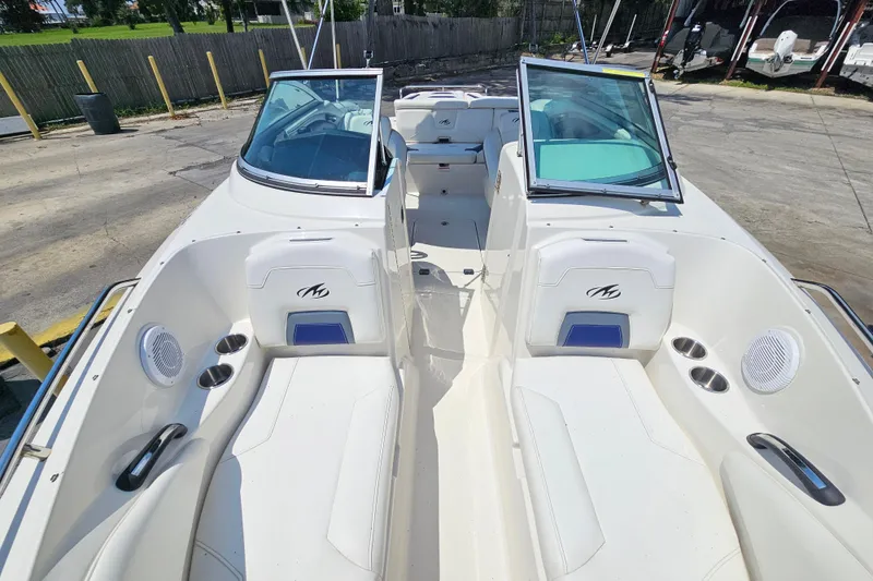 Slide: The Image of 2011 Monterey 244FS boat interior with white seating and open windshield. - 19