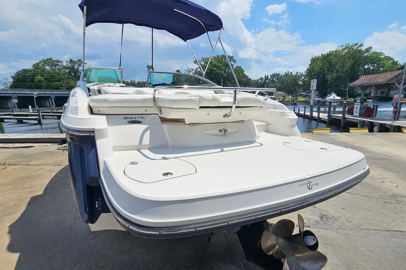 Slide: The Image of 2011 Monterey 244FS boat docked, featuring a spacious deck and blue canopy. - 4