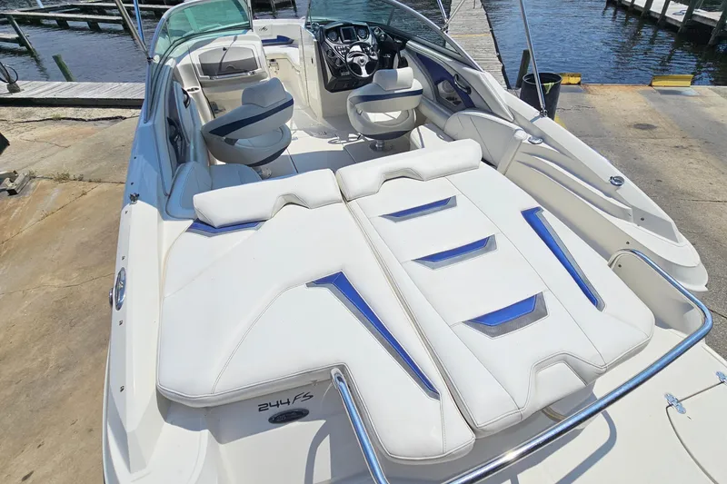 Slide: The Image of 2011 Monterey 244FS boat interior with white seating and steering wheel, docked by the water. - 8