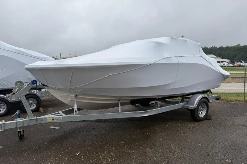 Slide: The Image of 2025 Bayliner V20i boat covered on trailer, parked outdoors on a cloudy day. - 0