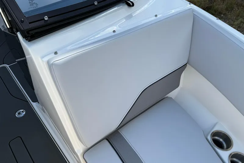 Slide: The Image of 2025 Bayliner V20i boat interior with white cushioned seating and cup holder. - 13