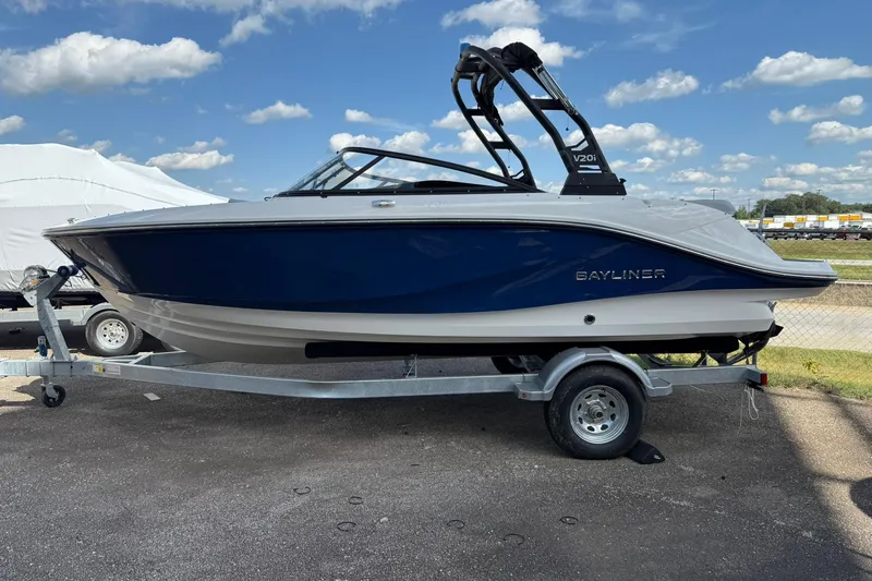 Slide: The Image of 2025 Bayliner V20i boat on trailer under blue sky. - 2