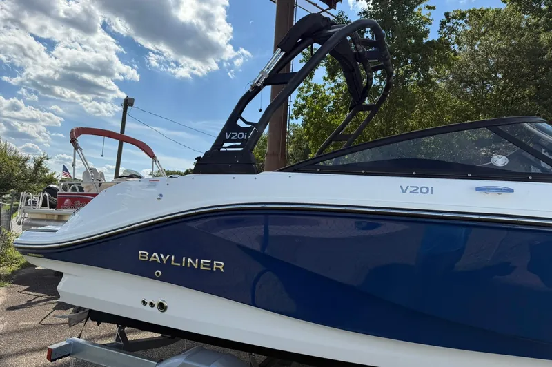 Slide: The Image of 2025 Bayliner V20i boat with sleek design, parked outdoors under a cloudy sky. - 4