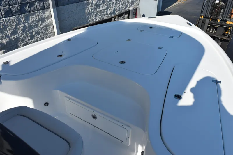 Slide: The Image of 2026 Sea Hunt BX 22 BR boat deck with storage compartments, in a marina setting. - 10