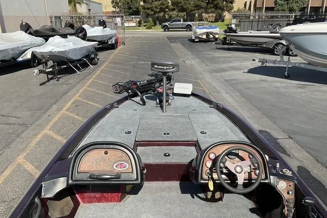 Slide: The Image of 2000 Ranger 518SVX Comanche boat interior with steering wheel and control panel in a parking lot. - 13