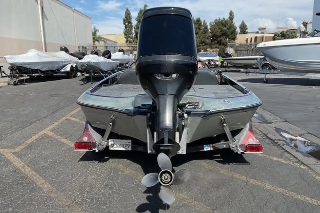 Slide: The Image of 2000 Ranger 518SVX Comanche boat with outboard motor, parked in a lot. - 15